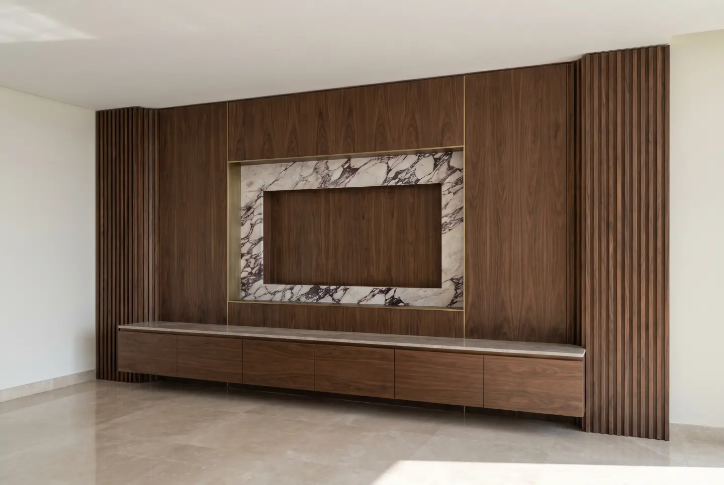 Full-wall walnut media panel with fluted returns and Calacatta Viola marble TV niche