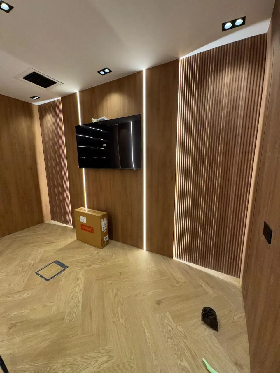 Walnut slat and flush-panel media wall with backlit LED reveals and mounted TV